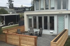 Fences - decorative horizontal slat cedar fence around a front yard patio with custom built in planter box