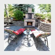 outdoor stone fireplace with lounge chairs on patio